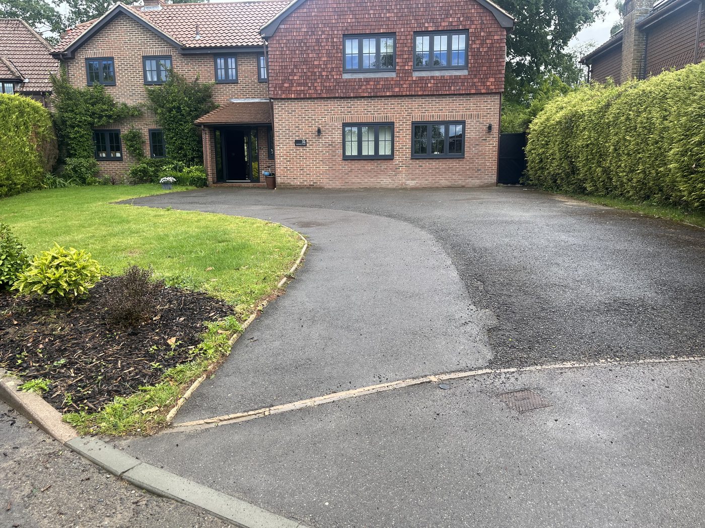 Worn tarmac driveway before resurfacing