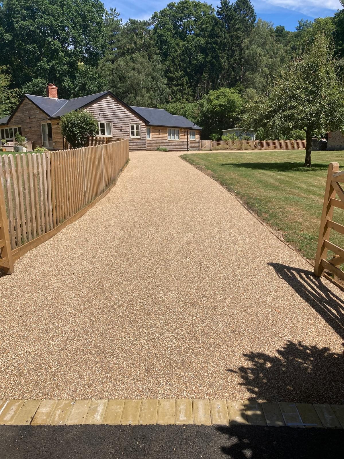 Tar and chip driveway sweeping up to a country home